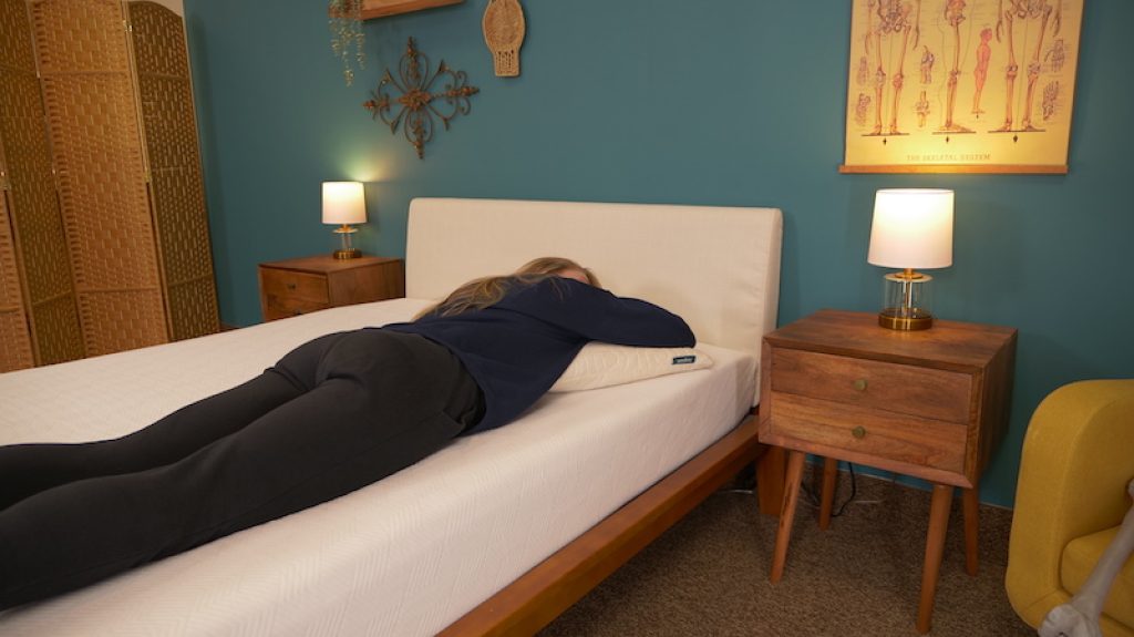 Julia Forbes testing a mattress for stomach sleeping