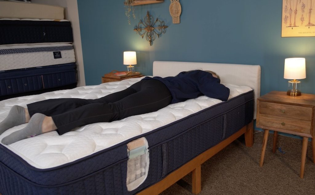 Julia Forbes testing a mattress in the stomach sleeper sleeping position